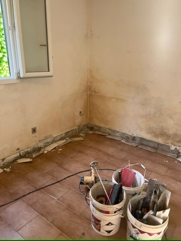 Parete con muffa e intonaco deteriorato prima del ripristino