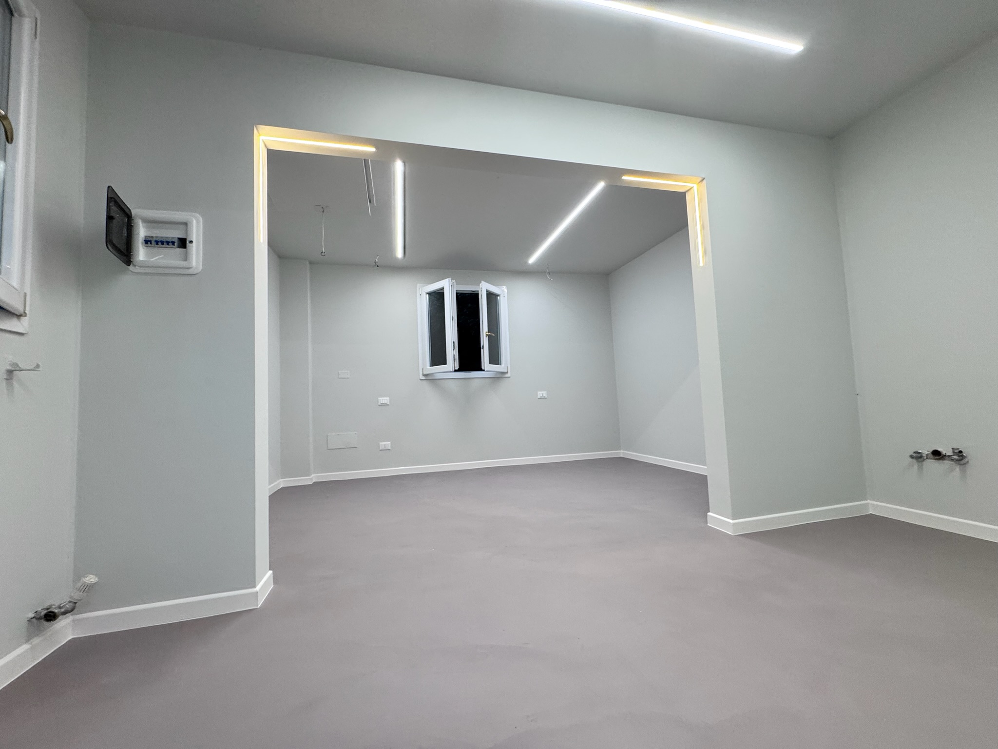 Appartamento finito con pareti grigio chiaro e illuminazione integrata